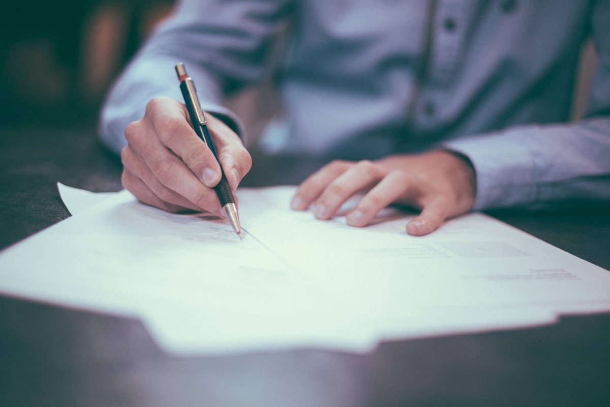 man-writing-pen-desk